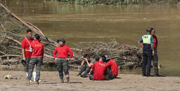 19일 오전 경북 예천군 호명면서 수색하던&nbsp;해병대원 1명이 급류에 휩쓸려 실종된 가운데&nbsp;해병대&nbsp;전우들이 침울한 표정으로 구조 소식을 기다리고 있다 / 연합뉴스