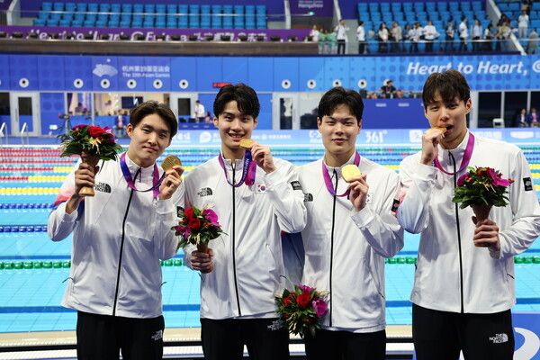 양재훈(왼쪽부터), 이호준, 김우민, 황선우가 25일 중국 항저우 올림픽 스포츠센터 수영장에서 열린 2022 항저우 아시안게임 수영 남자 800m 계영 결승 시상식에서 금메달을 획득한 뒤 환호하고 있다. /연합뉴스