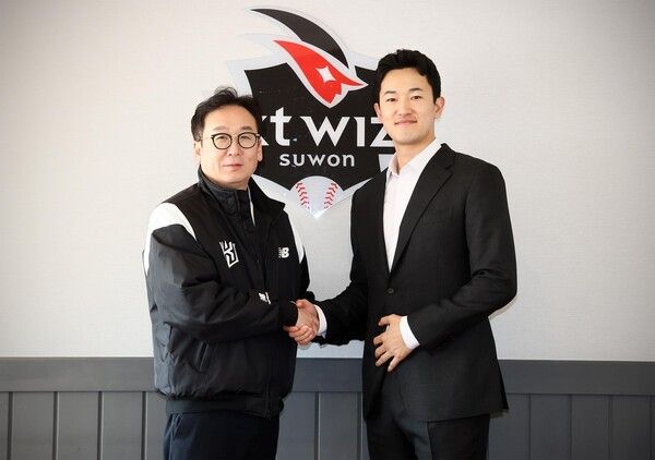 고영표(오른쪽)가 25일 수원KT위즈파크에서 KT 구단과 비FA 다년 계약을 맺은 뒤 나도현 KT 단장과 악수하고 있다. /구단 제공