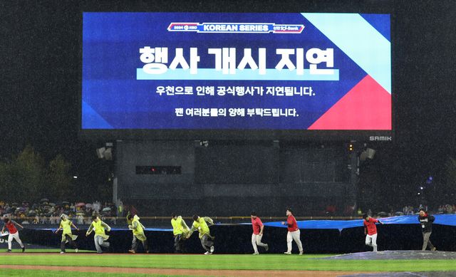21일 광주 기아챔피언스필드에서 열린 2024 신한 SOL뱅크 KBO 포스트시즌 한국시리즈 1차전 삼성 라이온즈와 KIA 타이거즈의 경기 시작 전 경기 관계자들이 우천으로 인해 세 번째로 방수포를 설치하고 있다. /연합뉴스