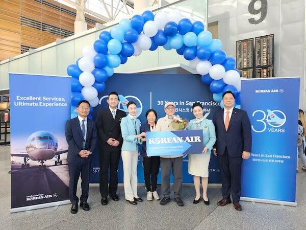 KE024편 30번째 탑승수속 승객이 샌프란시스코~인천 왕복 이코노미 항공권 1매를 전달받고 기념사진을 촬영하고 있다/대한항공 제공