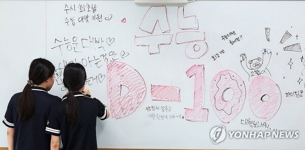 수험생들이 칠판에 수능 각오를 다지는 메시지를 적고 있다. /연합뉴스