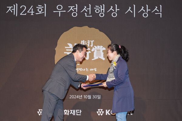 코오롱그룹 오운문화재단이 30일 개최한 '제24회 우정선행상 시상식'에 이웅열 오운문화재단 이사장(왼쪽)이 우정선행상 대상을 수상한 김선자&nbsp;씨에게 상장을 전달하고 있다./사진=코오롱그룹