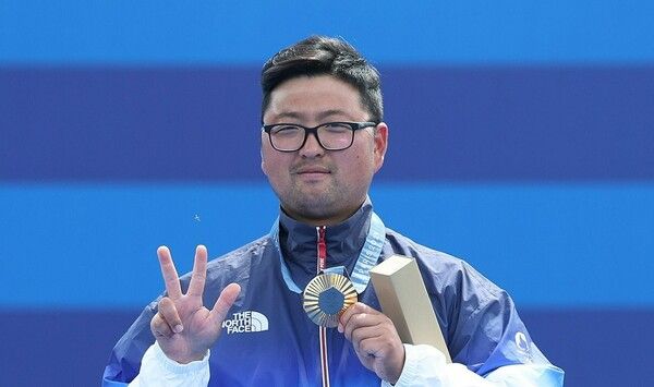 4일(한국 시각) 프랑스 파리 레쟁발리드에서 열린 2024 파리 올림픽 양궁 남자 개인전 결승전에서 금메달을 차지한 한국 김우진이 손가락으로 3관왕을 나타내고 있다. /연합뉴스