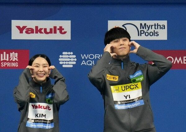 김수지(왼쪽)와 이재경이 10일(한국 시각) 카타르 도하 하마드 아쿠아틱센터에서 열린 2024 세계수영선수권 다이빙 혼성 3ｍ 스프링보드 결선에서 3위에 오른 후 '볼 하트 세리머니'를 하고 있다. /연합뉴스