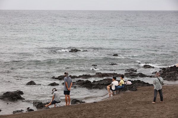 제주시 지역에 69일째 열대야 현상이 발생한 15일 아침 제주시 삼양해수욕장을 찾은 시민들이 바닷물에 발을 담그고 더위를 식히고 있다. /연합뉴스.