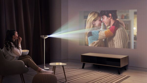 프로젝터에 인테리어 조명, 스피커를 결합한 3-in-1 형태의 신개념 프로젝터(PF600U)로 대화면 콘텐츠를 감상하는 모습./LG전자