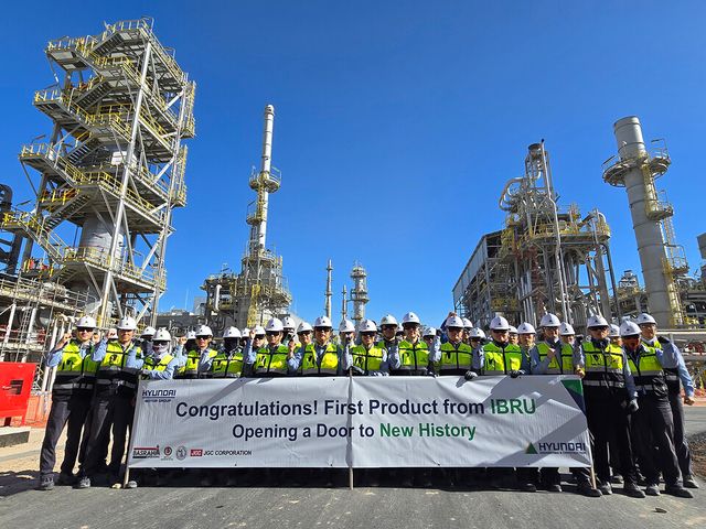 가솔린 생산을 축하하는 플래카드를 들고 이라크 바스라 정유공장 고도화설비 공사 현장 임직원들이 기념사진을 촬영하고 있다./현대건설