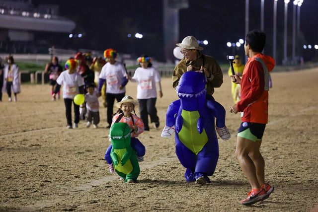 공룡 코스튬을 입은 가족이 경주로를 달리고 있다. /한국마사회 제공