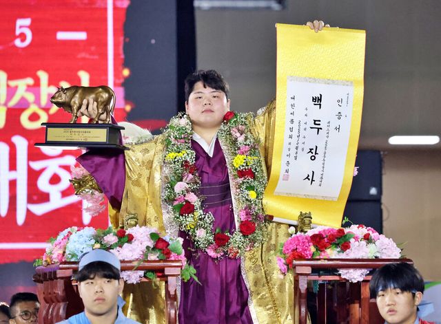 8일 울산 울주종합체육센터에서 열린 '위더스제약 2025 울주추석장사씨름대회' 백두장사(140kg이하)에 등극한 김민재(영암군민속씨름단)가 장사인증서와 황소트로피를 들고 기념사진을 찍고 있다. /연합뉴스