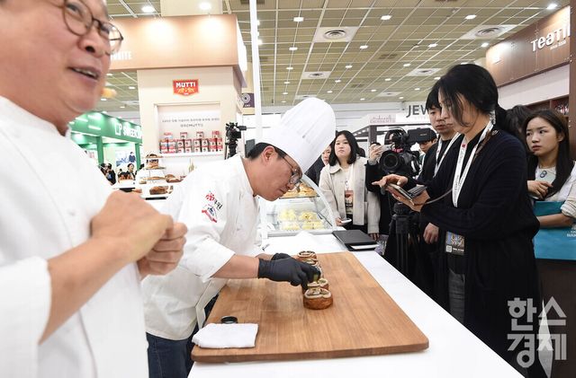 19일 서울 강남구 코엑스에서 2025 제24회 서울 카페쇼가 ‘ One Cup, All Worlds' 주제로 열린 가운데 방문객들이 한 부스서 디저트 제작 과정을 살펴보고 있다. / 이호형 기자 leemario@sporbiz.co.kr 2025.11.19