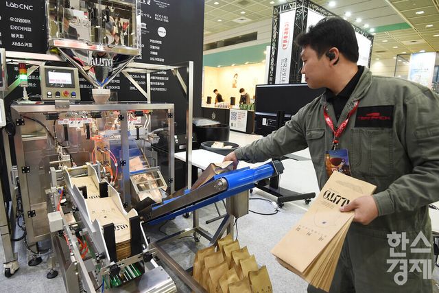 19일 서울 강남구 코엑스에서 2025 제24회 서울 카페쇼가 ‘ One Cup, All Worlds' 주제로 열린 가운데 한 부스서 커피 용기 자동화 기계를 선보이고 있다. / 이호형 기자 leemario@sporbiz.co.kr 2025.11.19