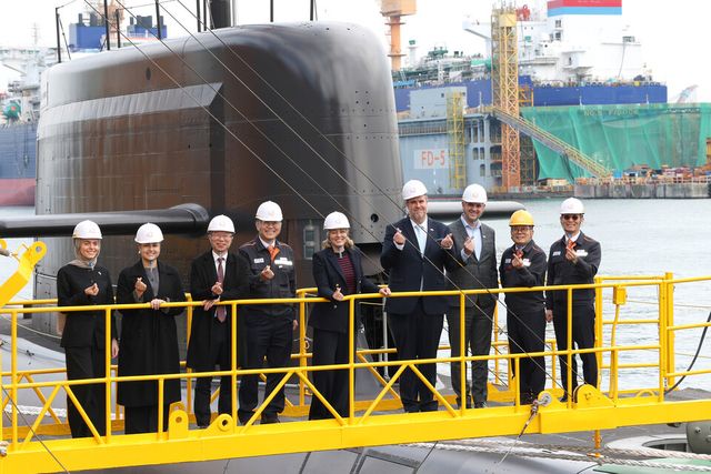 지난 24일 멜라니 졸리 캐나다 산업부 장관(가운데)이 김희철 한화오션 대표(왼쪽 네 번째), 강환석 방위사업청 차장(왼쪽 세 번째) 등과 함께 한화오션이 건조한 잠수함 ‘장영실함’을 배경으로 기념 촬영을 하고 있다./한화오션