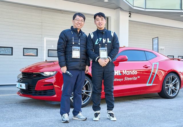 배홍용 HL만도 CTO 부사장(왼쪽)과 정의철 카레이서가 스티어바이와이어(Steer by Wire) 탑재 차량 앞에서 기념 촬영을 하고 있다./HL그룹