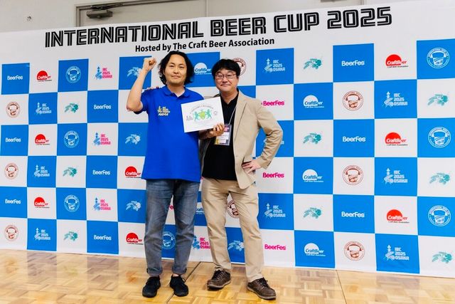 일본 오사카에서 열린 ‘2025&nbsp;인터내셔널 비어 컵(IBC)’ 시상식에서 구스아일랜드 브루하우스 이창현 브루마스터(왼쪽)가 카테고리 챔피언 상장을 들고 인터내셔널 비어 컵 테츠야 코지마(Tetsuya Kojima)&nbsp;디렉터와 함께 기념촬영을 하고 있다./오비맥주 제공.
