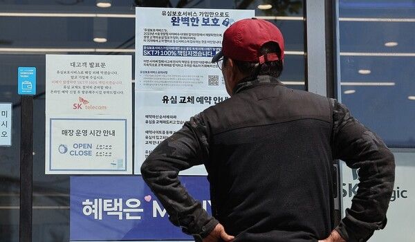 서울 시내의 한 SK텔레콤 대리점 앞에서 소비자가 유심 재고 소진 및 유심보호서비스 관련 안내문을 살펴보고 있다./연합뉴스
