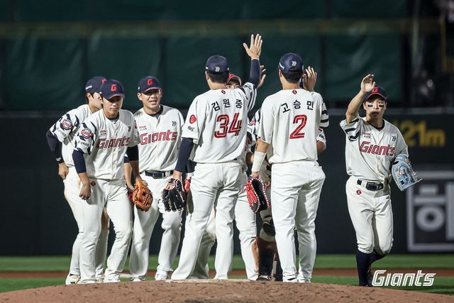 롯데 선수단이 6월 18일 한화 이글스전 승리 후 마운드에 모여 하이파이브하고 있다. /롯데 자이언츠 제공