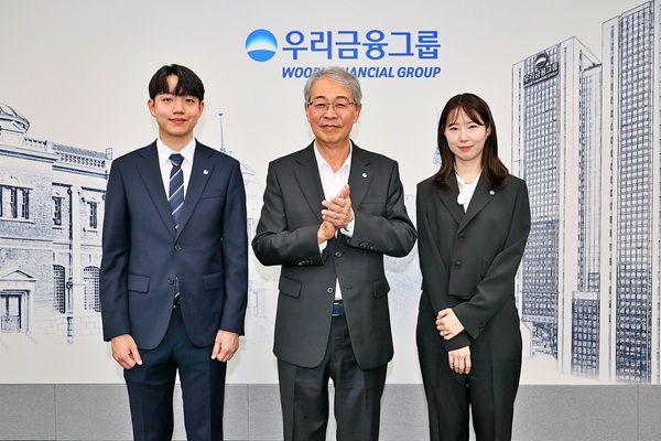 임종룡 우리금융그룹 회장이 그룹의 새 가족이 된 동양생명·ABL생명 직원에게 디지털 선도의 의미가 담긴 새로운 그룹 보조휘장을 달아주고 있다. /우리금융그룹 제공