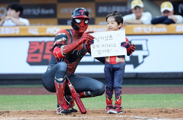 스파이더맨 분장을 한 박해민(왼쪽)이 아들 박이든 군과 함께 홍창기를 응원하고 있다. /연합뉴스