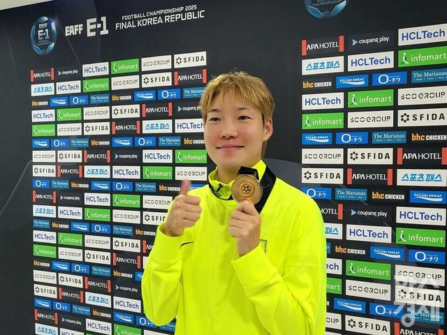 이금민이 경기 후 공동취재구역에서 메달을 들어보인 뒤 포즈를 취하고 있다. /신희재 기자