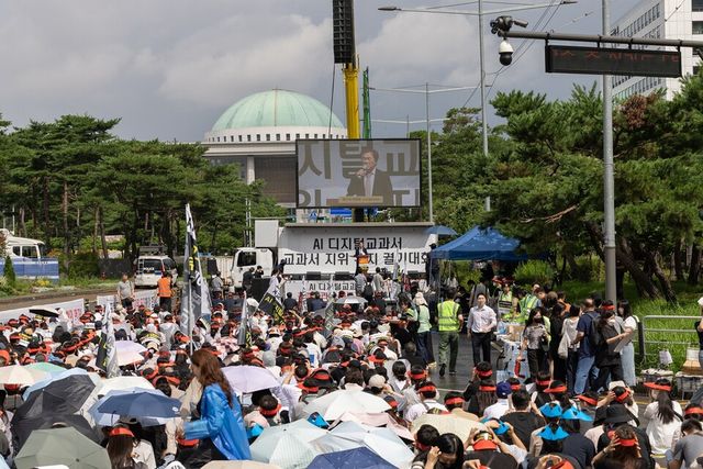 교과서발전위원회와 AIDT 발행사 등 교육계 관계자들은 21일 서울 여의도 국회 앞에서 열린 총궐기대회에서 AI 디지털교과서의 법적 지위 격하에 반대하며 정책 철회를 요구했다./천재교과서