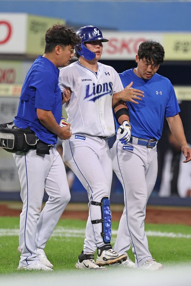 류지혁(가운데)이 부축받으며 더그아웃으로 돌아가고 있다. /삼성 라이온즈 제공