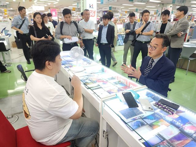 23일 서울 광진구 강변테크노마트에서 신승한 방송통신위원회 시장조사심의관이 휴대전화 유통점 관계자와 대화하고 있다./방송통신위원회 제공