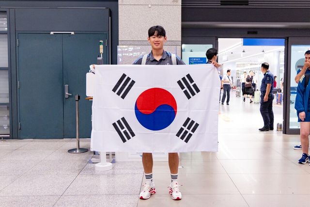 박승수가 입국장에서 태극기를 펼쳐들고 있다. /쿠팡플레이 제공