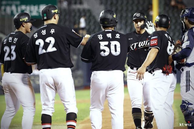 KT 선수단이 황재균의 만루홈런 직후 홈플레이트 근처에 모여 기뻐하고 있다. /KT 위즈 제공