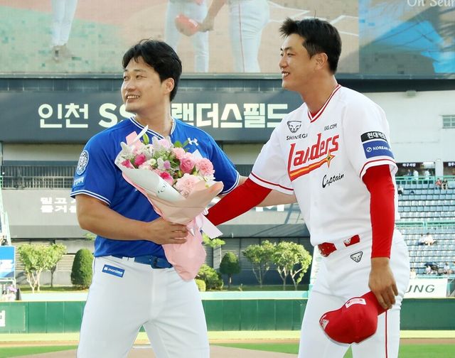 오승환(왼쪽)이 7일 SSG랜더스필드에서 열린 은퇴 기념행사에서 김광현에게 꽃다발을 전달받고 있다. /SSG 랜더스 제공&nbsp;