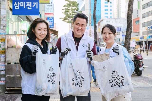 송영재 BAT로스만스 대표(가운데)와 임직원들이 길거리에 무단투기된 쓰레기를 수거한 후 기념사진을 촬영하고 있다./BAT로스만스 제공.