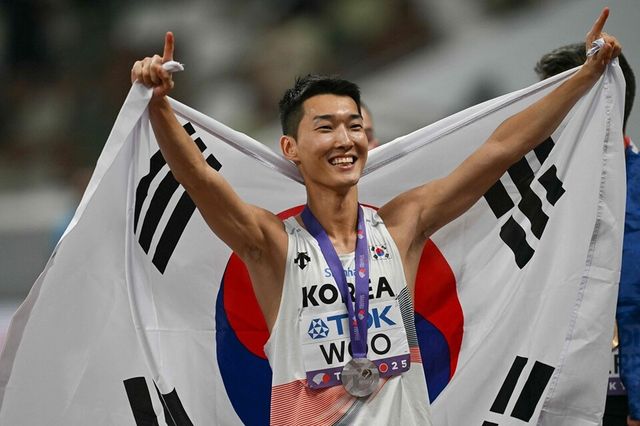 우상혁이 태극기를 펼쳐 보이며 기뻐하고 있다. /연합뉴스