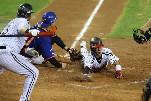 LG 신민재(오른쪽)가 한화 포수를 피해 홈에서 슬라이딩하고 있다. /LG 트윈스 제공&nbsp;