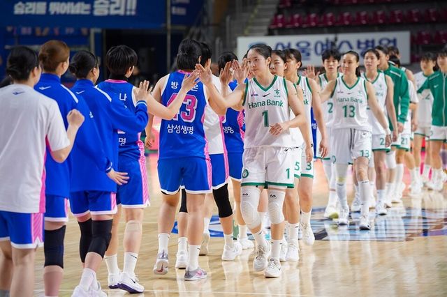 청색 유니폼의 삼성생명 선수단과 백색 유니폼의 하나은행 선수단이 경기 후 인사하고 있다. /WKBL 제공