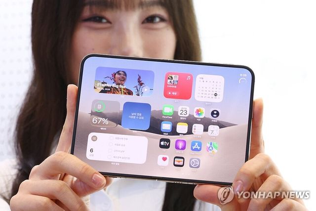 애플의 첫 폴더블 스마트폰 '아이폰 듀오'가 국내에 공식 출시된 23일 서울 마포구 LG유플러스 홍대입구점에서 모델이 제품을 선보이고 있다. /연합뉴스
