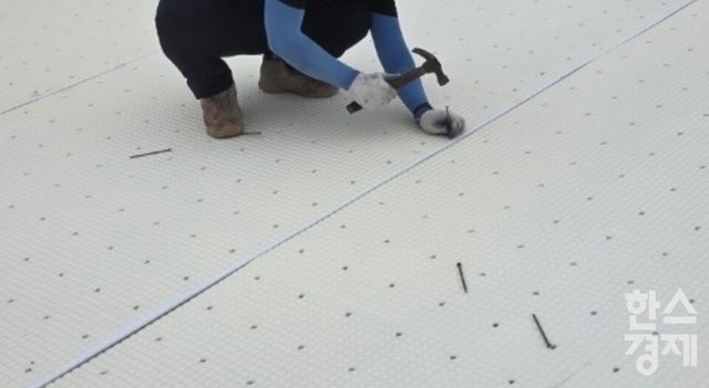 인조잔디 하부용 스펀지 발포패드를 못으로 고정하는 시공 현장 모습. /제보자 제공