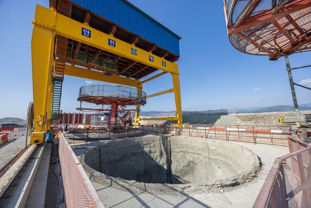 부산항 신항 북측 컨테이너부두 2단계 항만배후단지 조성 공사 현장의 갠트리 크레인 아래에 굴착이 완료된 수직터널./DL이앤씨