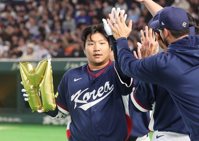 문보경이 2회 선제 투런포 직후 마이애미를 뜻하는 'M' 풍선을 들고 하이파이브하고 있다. /연합뉴스