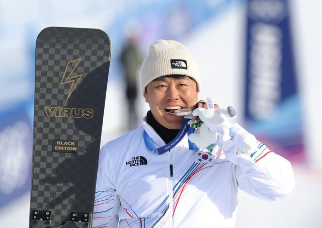 김상겸이 8일(한국 시각) 이탈리아 리비뇨 스노파크에서 열린 2026 밀라노-코르티나 동계올림픽 스노보드 남자 평행대회전 결승 시상식에서 은메달을 깨물어보고 있다. /연합뉴스