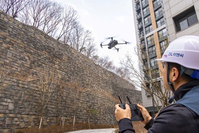 DL이앤씨 직원이 수도권의 한 아파트 입주 현장에서 육안 점검이 어려운 옹벽, 비탈면 등을 드론을 활용해 세밀하게 점검하고 있다./DL이앤씨