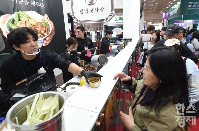 2026 IFS 프랜차이즈 창업·산업 박람회가 2일 서울 강남구 코엑스 C,D홀에서 열린 가운데 방문객들이 덮밥장사장 부스서 시식 음식을 받고 있다./ 이호형 기자 leemario@sporbiz.co.kr 2026.04.02