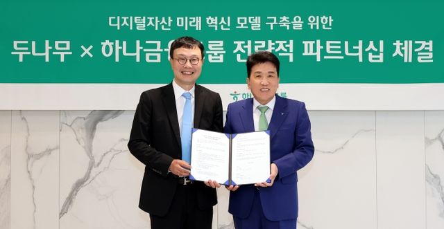 함영주 하나금융그룹 회장(오른쪽)이 지난 15일 하나금융그룹 명동사옥에서 두나무·하나금융그룹 전략적 파트너십을 체결한 후 김형년 두나무 부회장과 기념 촬영하고 있다./하나금융그룹