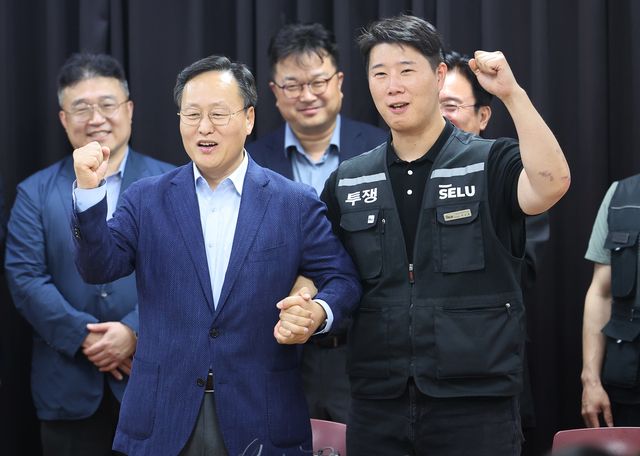경기도 수원시 장안구 경기고용노동청에서 20일 열린 삼성전자 임금협상을 마친 후 여명구 삼성전자 DS(디바이스솔루션·반도체 사업 담당) 피플팀장과 최승호 삼성그룹 초기업노동조합 삼성전자지부 위원장이 잠정 합의안에 서명한 후 파이팅을 외치고 있다./연합뉴스