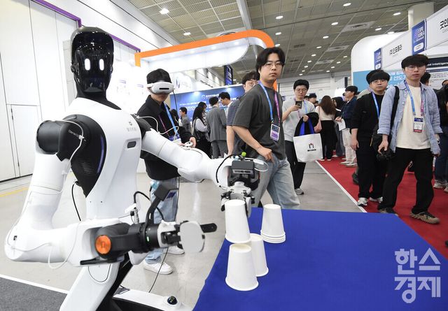 아시아 최대 규모의 AI 전시회 2026 국제인공지능대전 (AI EXPO KOREA 2026)이 6일 서울 강남구 코엑스 A홀에서 ‘인공지능의 모든 것(Everything of AI)’ 를 주제로 개막됐다.리얼리스토어 부스 담당자가 관람객에게 가상현실을 이용한 AGIBOT 시연을 선보이고 있다./ 이호형 기자 leemario@sporbiz.co.kr 2026.05.06