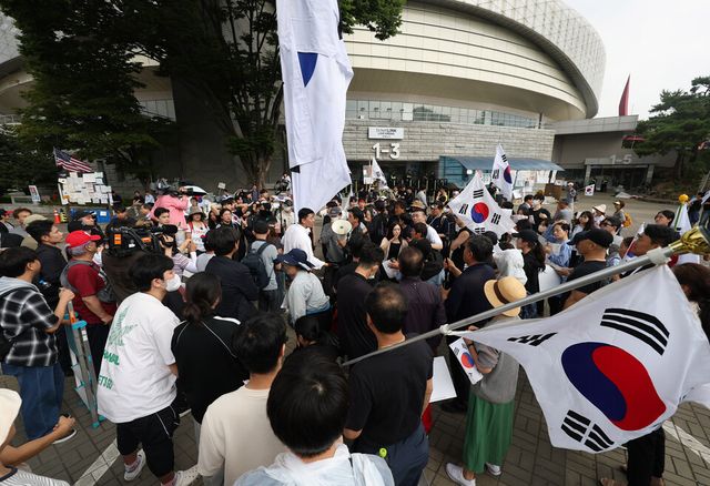 6·3 지방선거 투표용지 부족 사태를 규탄하는 개표소 봉쇄 집회가 이어진 10일 서울 송파구 올림픽공원 핸드볼경기장 앞에서 시위 참가자들이 경기장에 입주한 체육단체 직원들의 출입 허용 여부와 관련해 의견을 나누고 있다. /연합뉴스