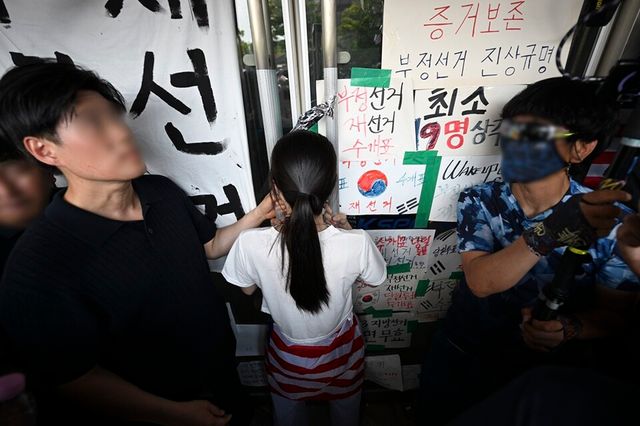 성조기를 두른 여성이 대한체육회 등 입주 단체 관계자들의 핸드볼경기장 진입을 막고 있다. /공동취재단