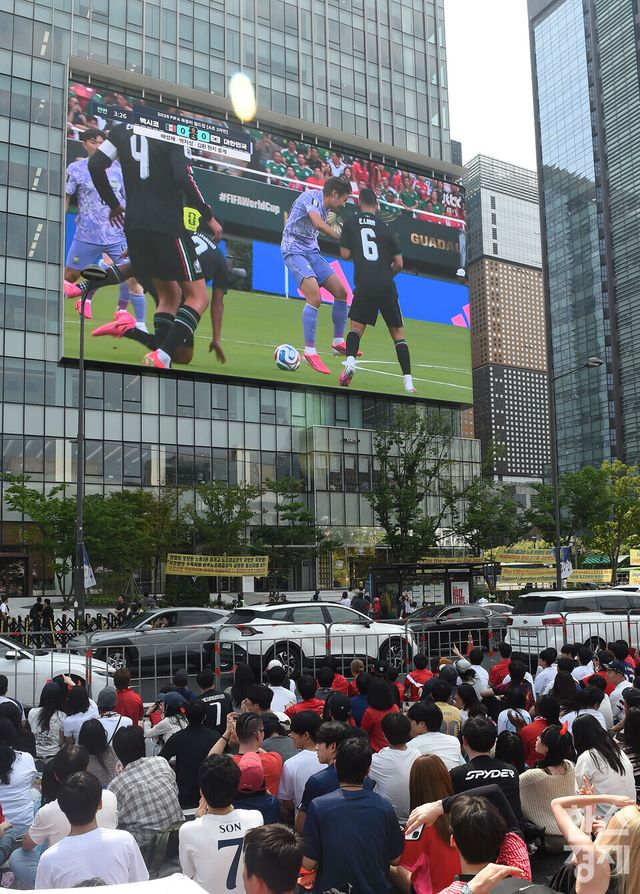 2026 FIFA 북중미 월드컵 대한민국 대 멕시코의 본선 두번째 경기가 열린 19일 오전, 서울 광화문광장에서 붉은악마와 시민들이 KT 광화문 사옥 빌딩 벽면에 설치된 초대형 미디어 파사드 스크린을 보며 열띤 거리 응원을 펼치고 있다./ 이호형 기자 leemario@sporbiz.co.kr 2026.06.19