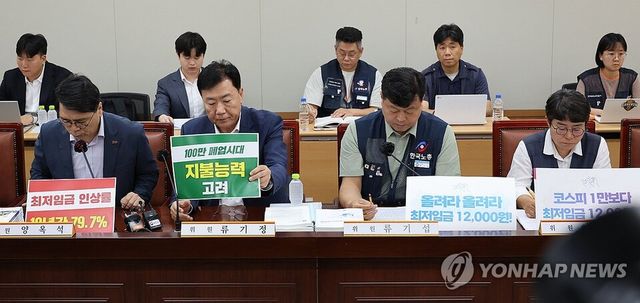 23일 정부세종청사 최저임금위원회에서 내년도 최저임금 인상률을 본격 논의하기 위한 제8차 전원회의가 열리고 있다.사용자위원인 양옥석 중소기업중앙회 인력정책본부장(왼쪽부터)과 류기정 한국경영자총협회(경총) 전무, 근로자위원인 류기섭 한국노총 사무총장과 민주노총 이미선 부위원장이 상반된 피켓을 세워놓고 있다. /연합뉴스
