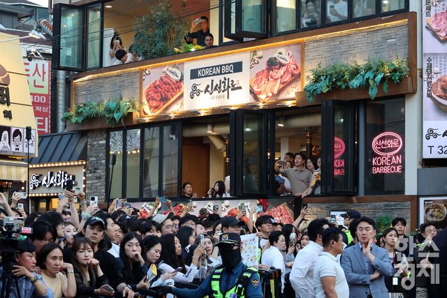 수많은 시민들이 5일 오후 서울 마포구 홍대입구역 인근 삼겹살 전문점에서 열린 젠슨 황 엔비디아 최고경영자(CEO), 최태원 SK그룹 회장,구광모 LG그룹 회장, 이해진 네이버 글로벌투자책임자(GIO)와 이른바 ‘삼겹살 회동’ 을 인근 상가에서 지켜 보고 있다./ 이호형 기자 leemario@sporbiz.co.kr 2026.06.05