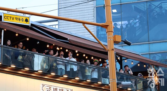 시민들이 5일 오후 서울 마포구 홍대입구역 인근 삼겹살 전문점에서 열린 젠슨 황 엔비디아 최고경영자(CEO), 최태원 SK그룹 회장,구광모 LG그룹 회장, 이해진 네이버 글로벌투자책임자(GIO)와 이른바 ‘삼겹살 회동’ 을 인근 상가에서 지켜 보고 있다./ 이호형 기자 leemario@sporbiz.co.kr 2026.06.05